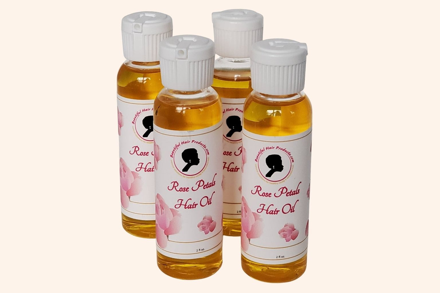 Four bottles of Rose Petals Scalp & Hair Oil bottle, 2oz with pink and cream label featuring rose petals for scalp and hair nourishment